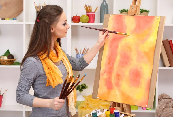 Mooie jonge vrouw schilder op het werk, op kamer interieur achtergrond — Stockfoto