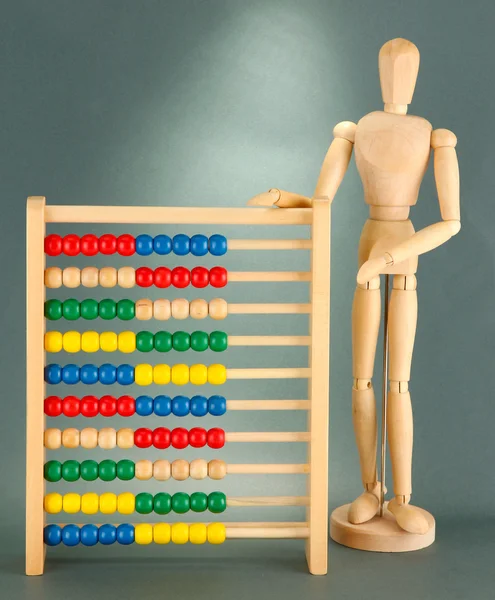 Heldere speelgoed abacus en houten pop, op grijze achtergrond — Stockfoto