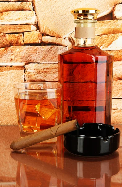 Bottle and Glass of whiskey and cigar on brick wall background — Stock Photo, Image