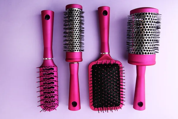 Comb brushes on purple background — Stockfoto