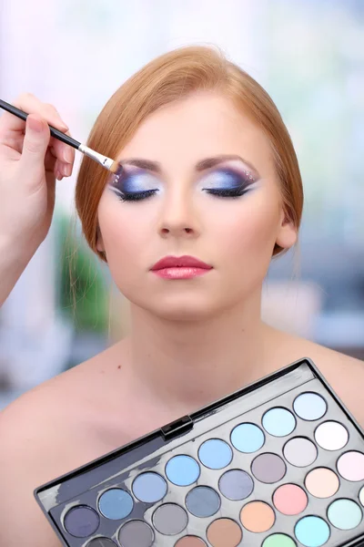 Portret van mooie jonge vrouw met het maken van make-up in beauty salon — Stockfoto