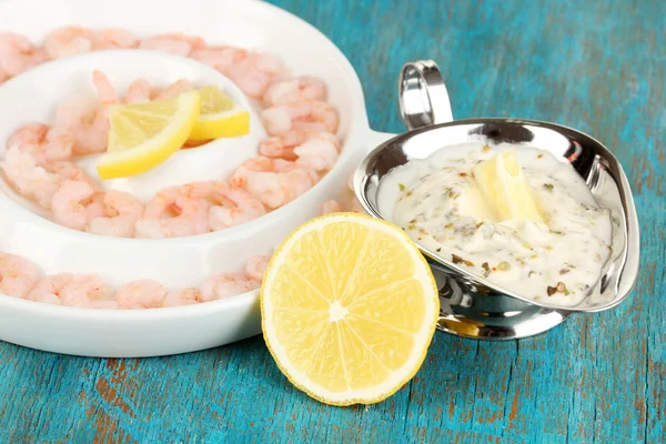 Plaka üzerinde mavi ahşap masa yakın çekim limonlu karides — Stok fotoğraf