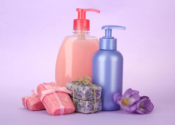 Liquid and hand-made soaps on purple background — Stock Photo, Image