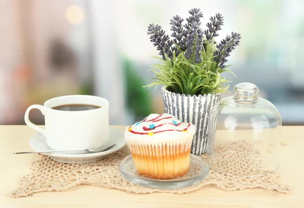 Cupcake auf Untertasse mit Glasabdeckung, auf hellem Hintergrund — Stockfoto