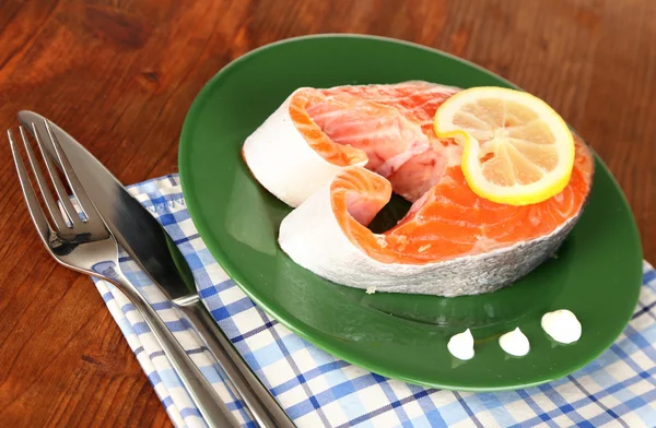 Pezzo di pesce rosso sul piatto con spezie e salsa sul tavolo di legno primo piano — Foto Stock