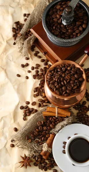 Cup of coffee, pot and grinder on beige background — Stock Photo, Image