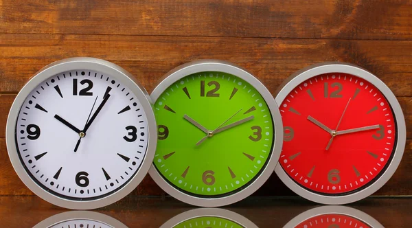 Round office clocks on wooden background — Stock Photo, Image