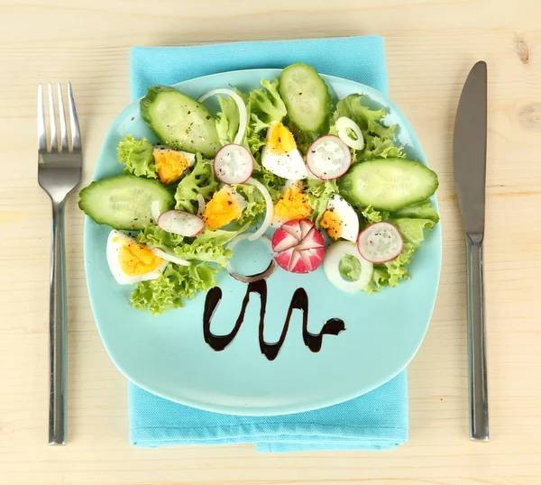 Friss vegyes saláta, tojás, saláta levelek és egyéb zöldségek, a lemez, színes, fából készült háttér — Stock Fotó