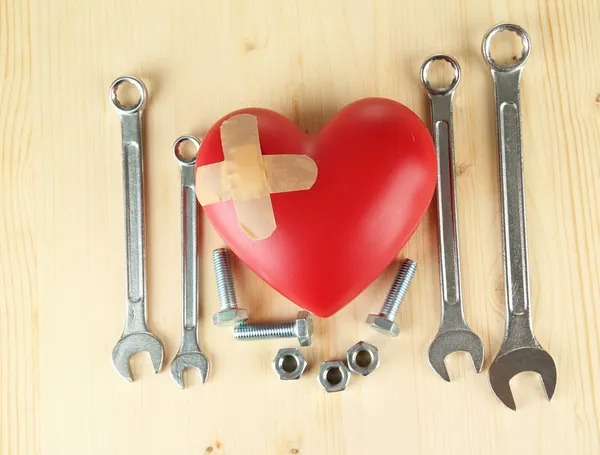 Heart and tools. Concept: Renovation of heart. On wooden background — Stock Photo, Image