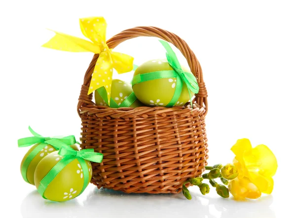 Luminose uova di Pasqua con fiocchi in cesto, isolate su bianco — Foto Stock