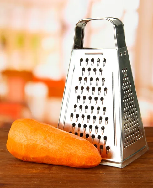 Metal grater and carrot, on bright background — Stock Photo, Image