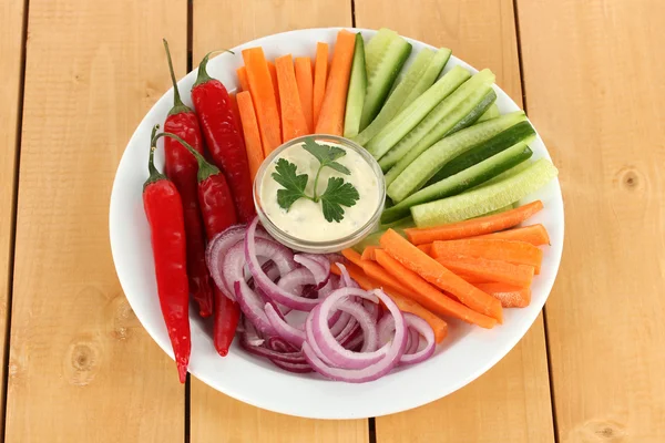 Assorted raw vegetables sticks in plate on wooden table close up — Stock Photo, Image