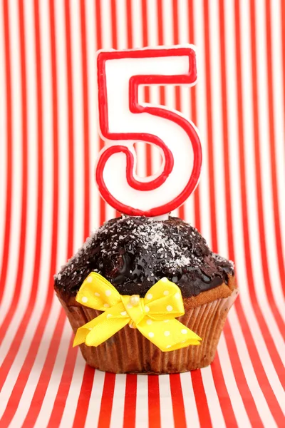 Cupcake di compleanno con glassa al cioccolato su sfondo a strisce — Foto Stock