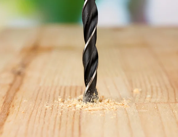 Imagem de close-up do furo de perfuração na prancha de madeira, sobre fundo brilhante — Fotografia de Stock