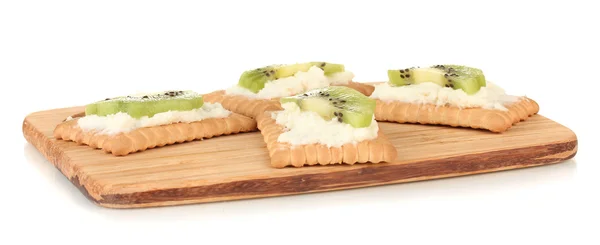 Knäckebröd met kaas en kiwi, op snijplank, geïsoleerd op wit — Stockfoto