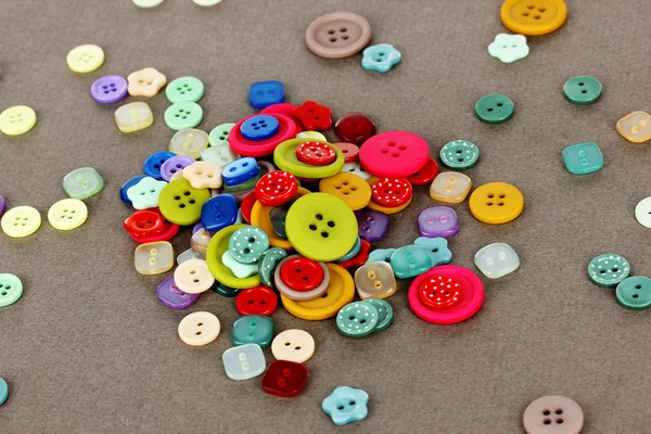 Botões de diferentes formas, tamanhos e cores close-up no fundo cinza — Fotografia de Stock