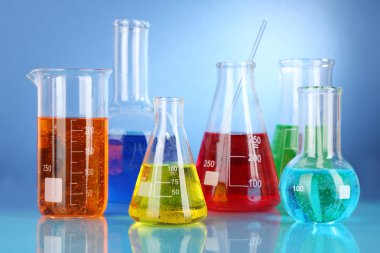 test tüpleri ile mavi arka plan üzerinde renkli sıvı