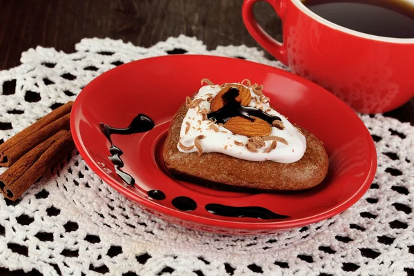 Schokoladenkeks in Herzform mit Tasse Kaffee auf Holztisch in Großaufnahme — Stockfoto