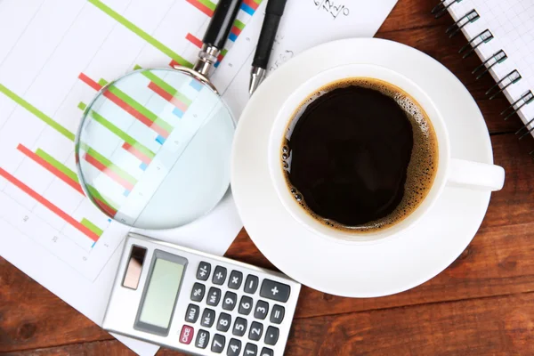 Xícara de café na mesa de trabalho coberto com documentos de perto — Fotografia de Stock