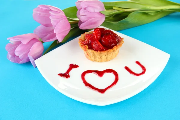 Zoete cake met aardbei en saus op plaat, op een achtergrond met kleur — Stockfoto