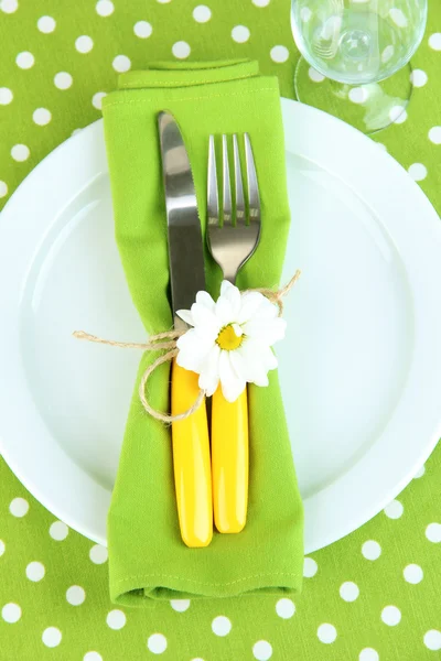 刀和叉上裹在餐巾上板、 彩色桌布背景 — 图库照片