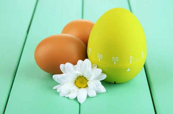 Groene ei timer en eieren, op een houten achtergrond kleur — Stockfoto