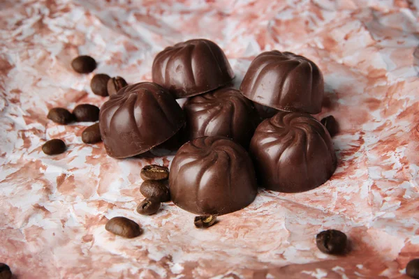 Choklad godis och kaffe bönor, på färgbakgrund — Stockfoto