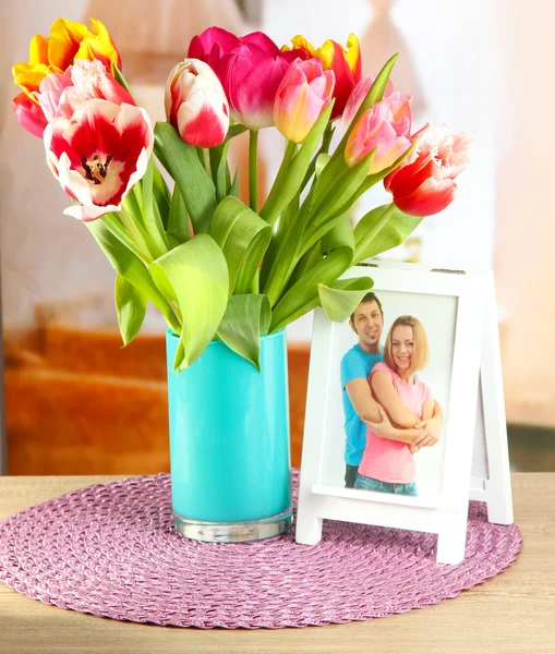 Hermosos tulipanes en cubo en la mesa en la habitación — Foto de Stock