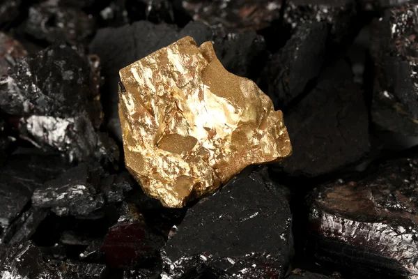 Golden nugget on coals background close-up — Stock Photo, Image