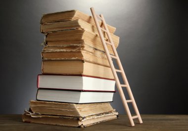 eski kitaplar ve Ahşap merdiven, gri arka plan üzerine