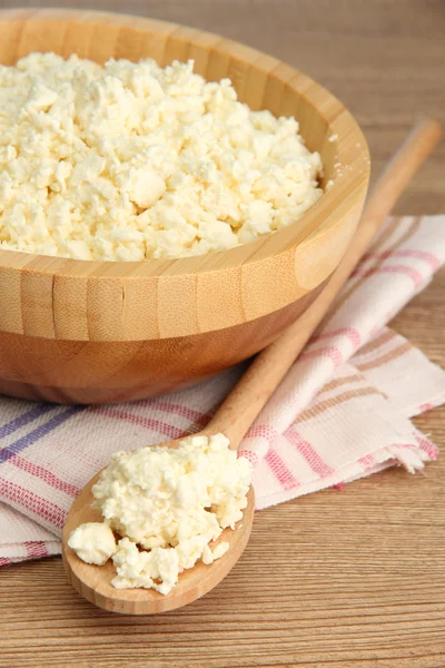 Cottage cheese in bowl on wooden table — Stock Photo, Image