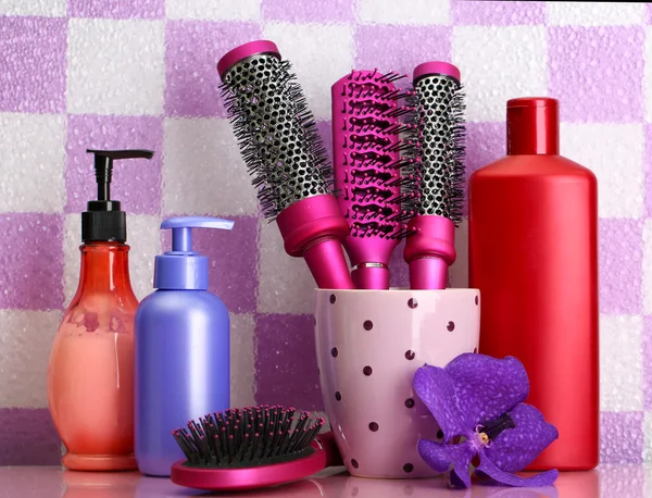 Brosses à cheveux et bouteilles cosmétiques en bathroo — Photo