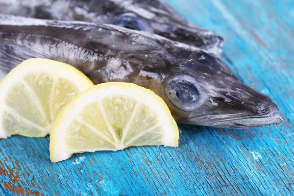 Fish with lemon on blue wooden table — Stock Photo, Image