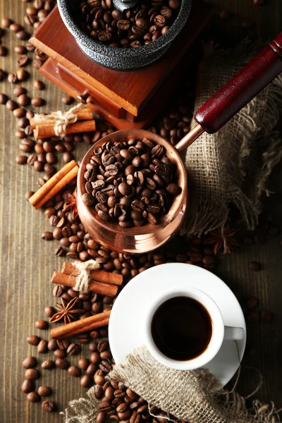 Cup of coffee, pot and grinder on wooden background — Stock Photo, Image