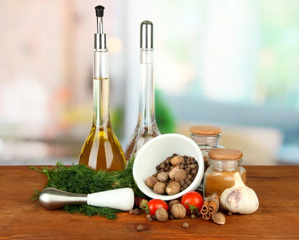 Composition of mortar, bottles with olive oil and vinegar, and green herbals, on bright background — Stock Photo, Image