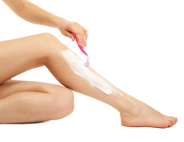 Beautiful woman is shaving her leg, isolated on white — Stock Photo, Image