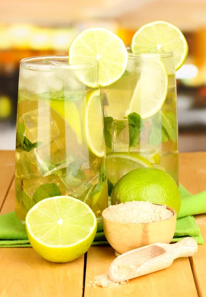 Verres de cocktail à la chaux et menthe sur table en bois sur fond lumineux — Photo