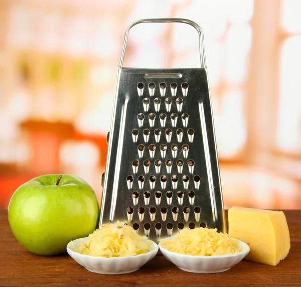 Ralador de metal e queijo, maçã sobre fundo brilhante — Fotografia de Stock