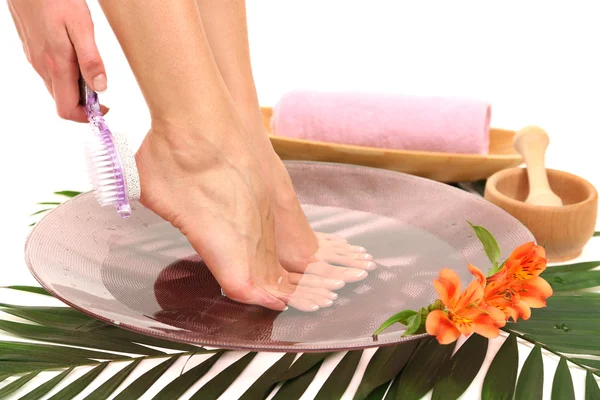Kvinnliga fötter i spa skål med vatten, isolerad på vit — Stockfoto