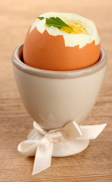 Boiled egg in egg cup, on wooden table — Stock Photo, Image