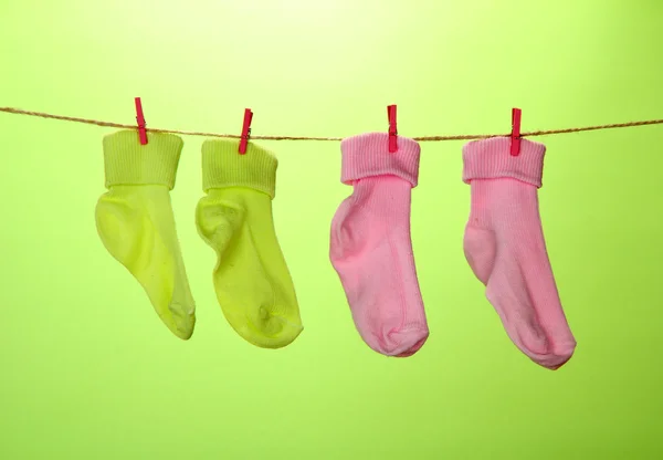 Calzini colorati appesi alla clothesline, su sfondo colore — Foto Stock