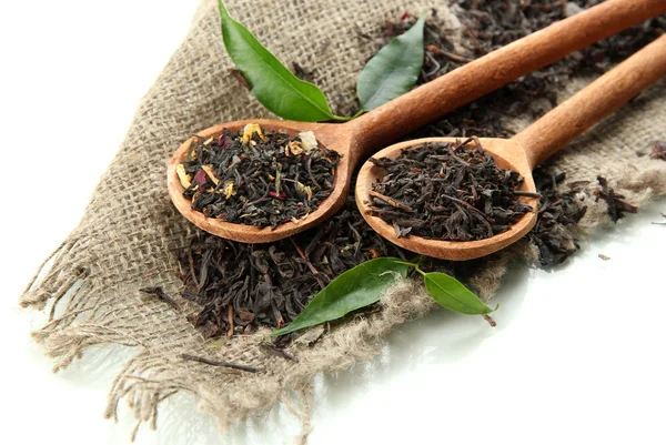 Dry tea with green leaves in wooden spoons, isolated on white — Stock Photo, Image