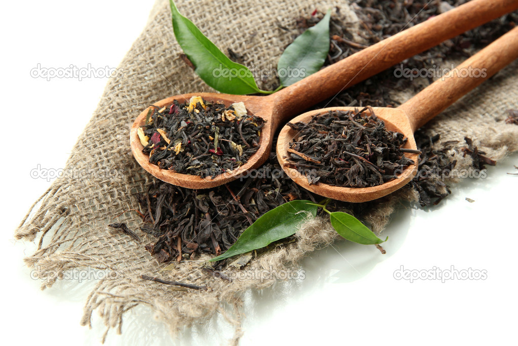 Dry tea with green leaves in wooden spoons, isolated on white — Stock