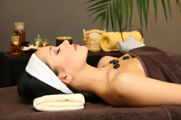 Belle jeune femme dans le salon de spa, sur fond sombre — Photo