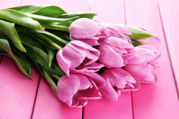 Mooi boeket van paarse tulpen op roze houten achtergrond — Stockfoto