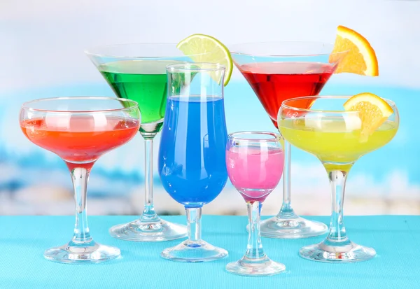 Glasses of cocktails on table near pool — Stock Photo, Image