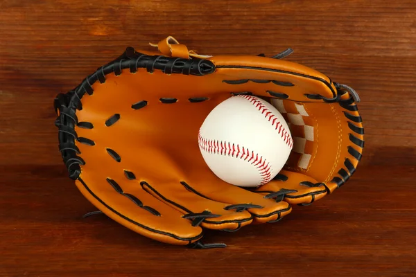 Honkbal handschoen en bal op houten achtergrond — Stockfoto