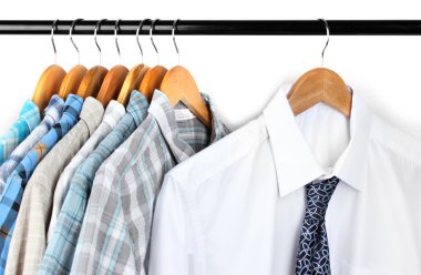 Shirts with ties on wooden hangers on light background clipart