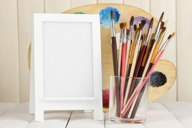 Fotoğraf çerçevesi şövale ahşap arka plan üzerinde sanatçının araçlarıyla olarak