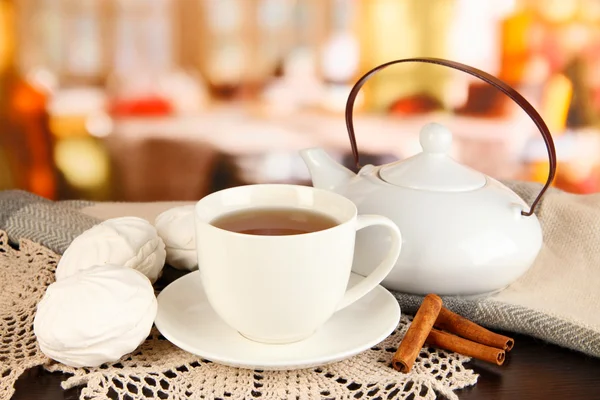 Cup of tea with scarf on table in room — Stock Photo, Image